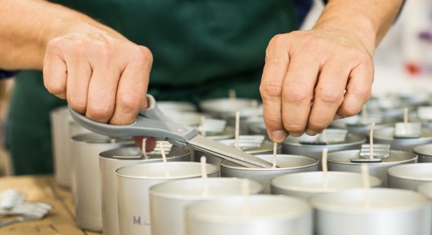 Coupe des mèches de bougies coulées dans des contenants en aluminium