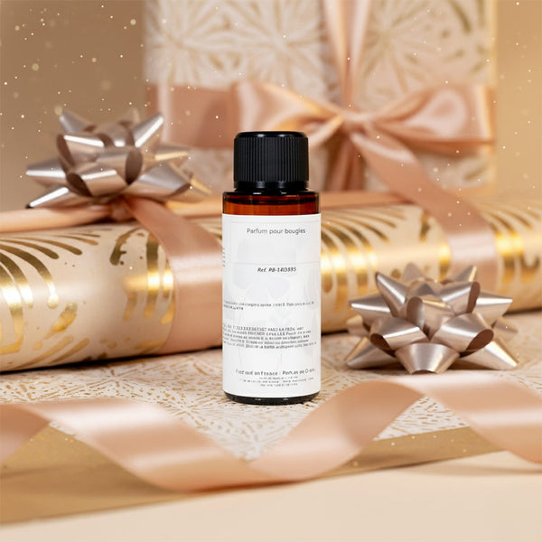 Flacon de parfum 30 ml offert, posé sur un papier cadeau avec nœuds argentés