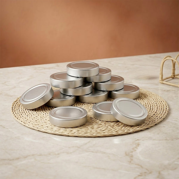 Pile de couvercles argent pour bocaux de 212 ml sur set rond en fibre naturelle