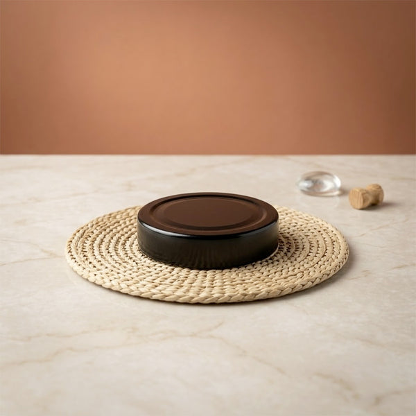 Couvercle noir pour bocal de 212 ml sur set rond en fibre naturelle