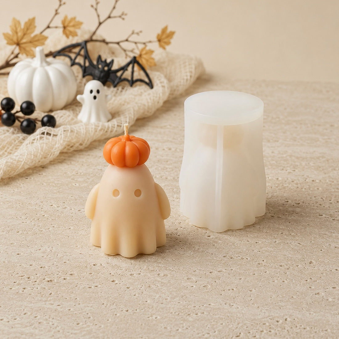 Bougie fantôme roi en cire beige à côté de son moule en silicone blanc