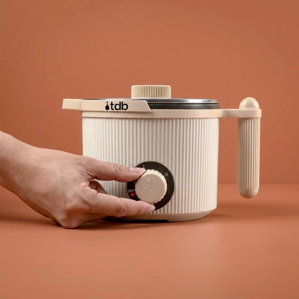 Main réglant la molette du fondoir à cire électrique sur fond orangé