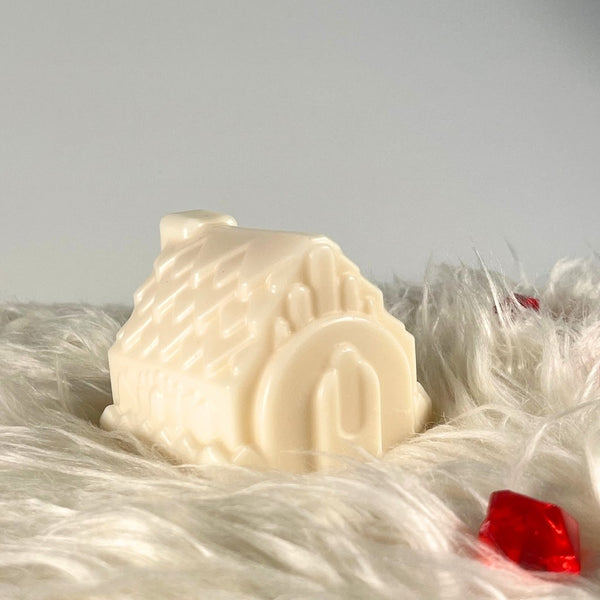 Bougie chaumière en cire crème posée sur une fourrure blanche