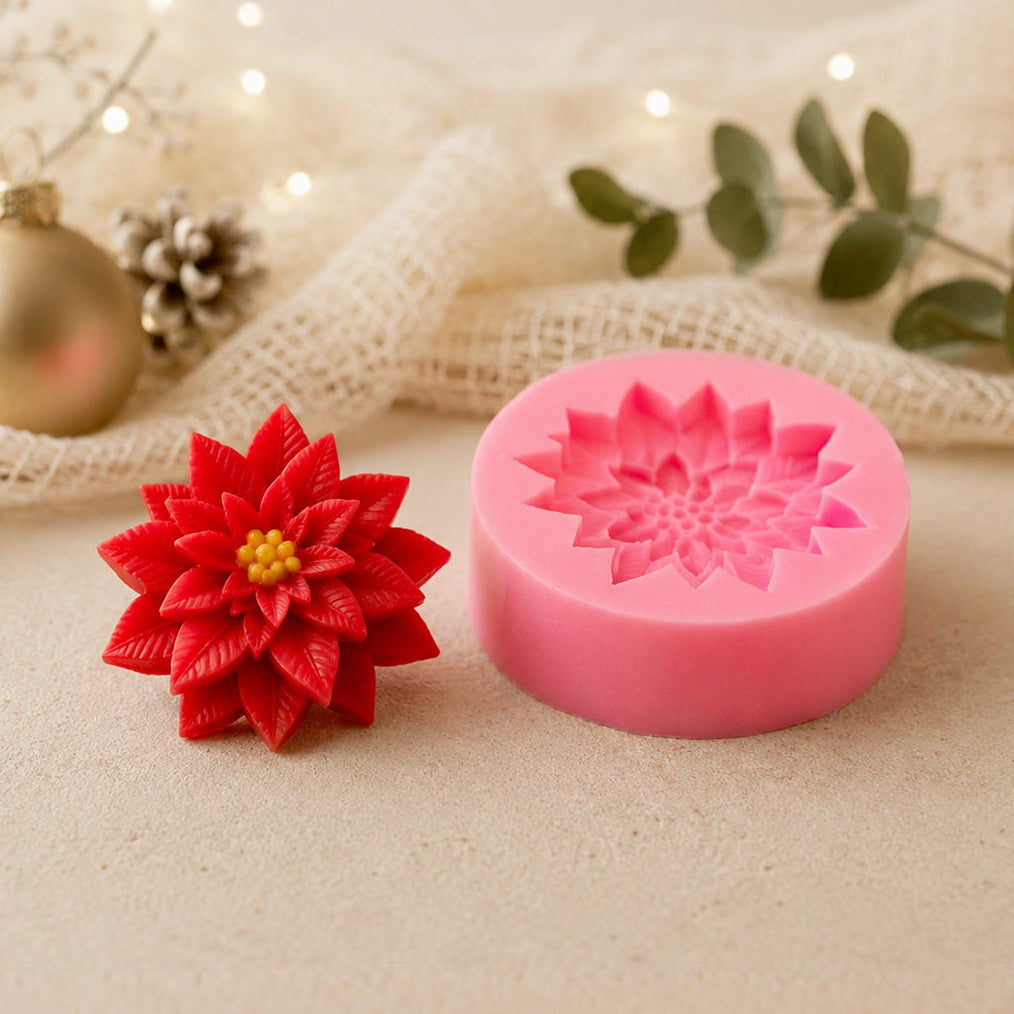 Décoration poinsettia rouge démoulée à côté de son moule en silicone rose
