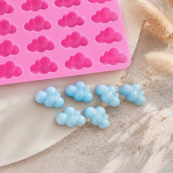 Moule en silicone rose en forme de nuages et fondants bleus démoulés