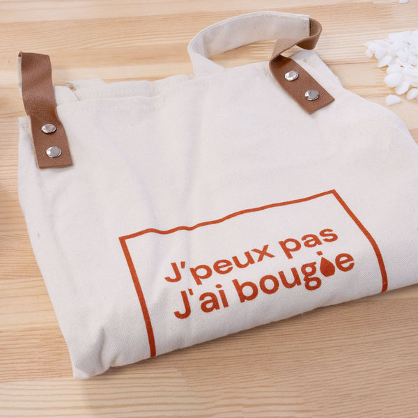 Tablier Terre de Bougies plié, sangles en cuir et flocage orange