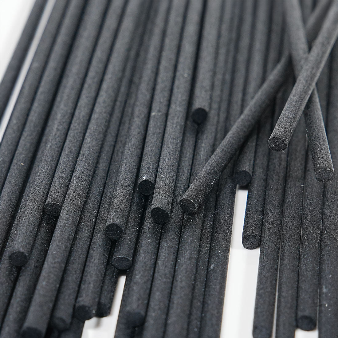 Tiges en fibre noire de 4 x 250 mm en vrac, vues de près