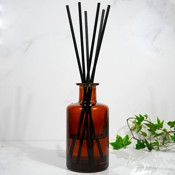 Diffuseur en verre ambré garni de tiges en fibre noire